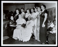 Charlotta Bass at an event with nine other women wearing full-length dresses, 1940s