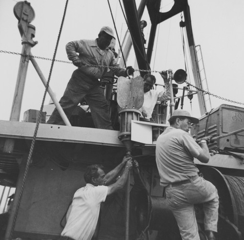 Frank Nolan, George Hetzel, Jim Faughn, Jim Snodgrass secure Maxwell's temperature probe to AH bulkhead, MidPac Expedition