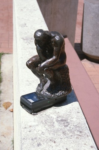 Something Pacific: detail: bronze figurine of Rodin's "The Thinker" on top of miniature portable television
