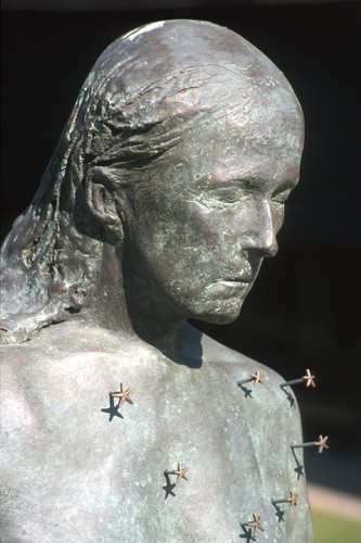 Standing: detail view of head and upper half of torso, with tiny representations of starfish configured as the constellation Virgo