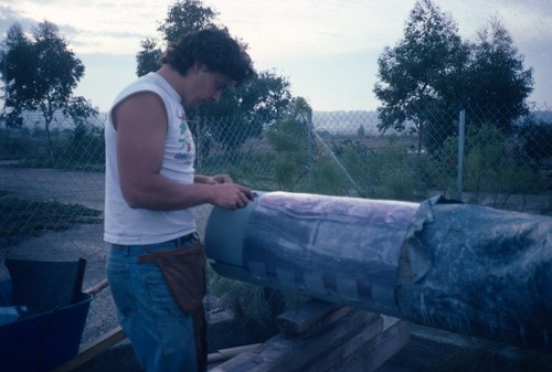 Trees: lead sheets being applied to eucalyptus tree in back lot at UCSD prior to installation on campus