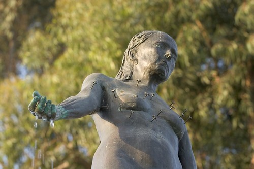 Standing: detail view of upper half of bronze figure, with water