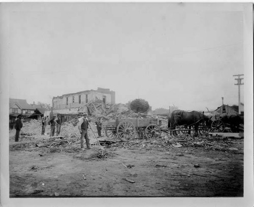 Work crew and two-horse carts clear debris