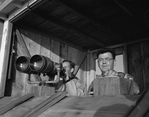 Carl L. (Carl Leavitt) Hubbs and Sam Hinton watch whales through military binoculars at Scripps Institution of Oceanography. Circa 1950