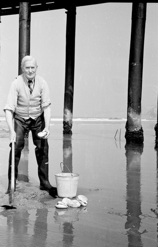 Wesley Roswell Coe (1869-1960) an invertebrate zoologist and marine biologist whose studies at ran the gamut, from investigations into embryology, physiology and morphology. He was especially known for his research on bathypelagic forms. He is shown here working on the beach near the Scripps Institution of Oceanography. Circa 1948