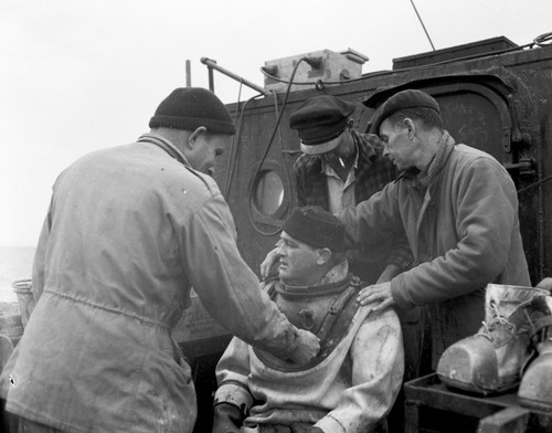 The "Salvager" employed by the Drakes Navigators Guild under Captain Adolph Oko Jr. (far right in this photo), explores Drakes Bay near San Francisco for small vessels rumored to have been left by explorer Frances Drake in 1579. This photograph was published in the San Francisco Chronicle. September 23, 1951