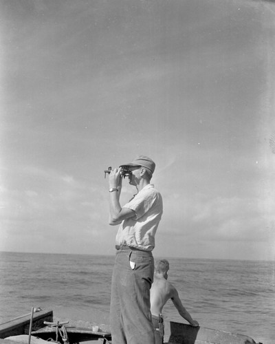 Marine Geologist Francis Shepard takes a fix for bottom studies on the "buoy boat," off La Jolla Shores. Al Allanson steers