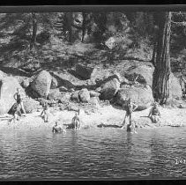 Children and adults playing and swimming in a river