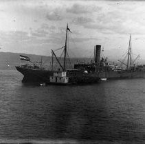 Freight ship along side of barge