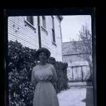 A woman posed in the driveway of a house