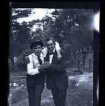 Two men holding a bottle of beer