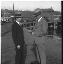 Two unidentified men standing on a dock