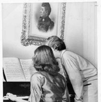 Two women at piano inside Stanford Home