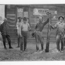 Photograph of six unidentified men in historic dress standing in fromt of a store in the State Historic Park