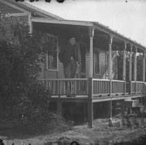 Exterior view of a man standing on the porch of a house