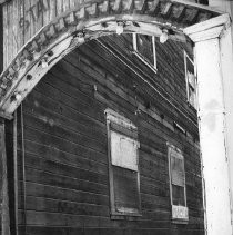 Cat in Locke Looks at Weathered Wooden Building