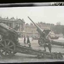 A U. S. soldier standing next to canon in Paris, France