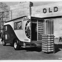 Exterior view of the Old Home Bakers company makers of Old Home and Betsy Ross Bread with one of their delivery trucks parked in front