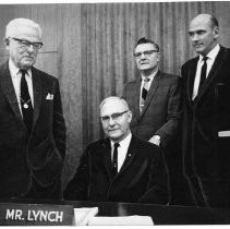 Caption reads: "New Chief, John W. Lynch, seated is new chairman of the state board of equalization with his fellow board members behind him. They are from left to right: Paul R. Leake, George R. Reilly, and State Controller, Alan Cranston."