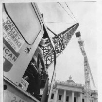 A crane operator maneuvers the crane agains the California State Capitol building during the restoration project