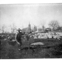 Chinese laborer carrying buckets in foreground of Methodist Church and Davis House, pre 1900