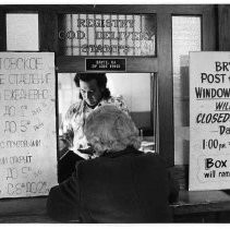In the Bryte Post Office, postal Supt. Tony Fonseca waits on a customer. Because of the large Russian-speaking population, the post office has signs in two languages