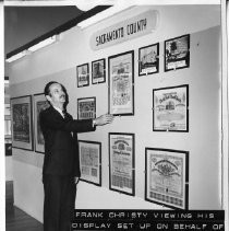 View of Frank Christy with his display of documents and photographs on behalf of the Sacramento County Historical Society. Display was installed in Pioneer Hall as part of the new City and County Museum's inaugural exhibition in 1967