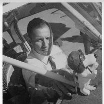 Dr. Alvin Marks, pilot and owner of Skymark Airlines, in the cockpit of his plane with a Snoopy stuffed animal