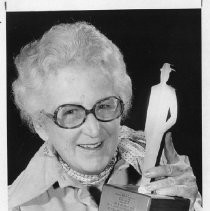 Mary Jackson, home economics director of the Sacramento Bee, holds the first-place trophy for outstanding men's wear coverage, at the fashion industry's 17th annual Lulu Awards in Chicago