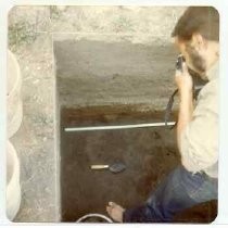 Photographs of landscape of Bolinas Bay. Open trench with tool inside, man standing in trench taking a photograph