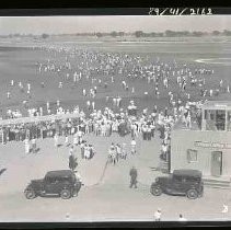 A crowd of people standing on an airport runway