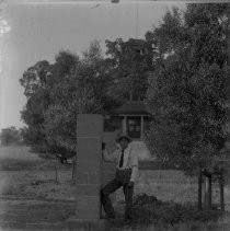 View of a man standing next to a cinder block column
