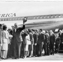 President Lyndon B. Johnson, having exited Air Force One on a 1964 campaign visit to Sacramento, waves to crowd with his cowboy hat