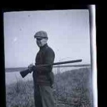 A young men standing on the bank of a wetland lake