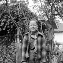 Boy in Boy Scout uniform standing if front of a home