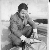 Dr. Alvin Marks, pilot and owner of Skymark Airlines. Here, Marks checks his one-man life raft and other emergency packs