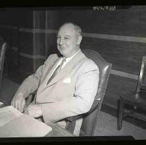 Unidentified man seated in an armchair