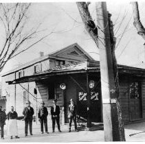 Exterior view of saloon, one door reads "The Sunrise" and the other reads "John Kost"