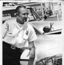 Elmer R. McBeath, Jr, Fire Chief, leans on the hood of his car