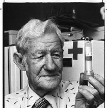 Charles Glover, holding test tube containing medical information