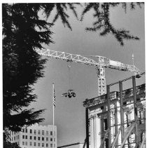 The crane at the California State Capitol restoration project raises a vehicle high in the sky above the work area
