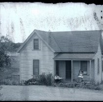 View of a farm house in Fair Oaks, possibly Barnheisel's or Bramhall's ranch. A family of three are on the porch