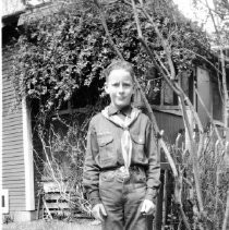 Boy in Boy Scout uniform standing if front of a home
