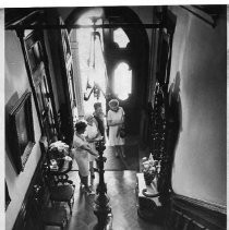 Stanford Home interior view from stairway, with four women at foot of stairway