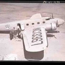 An airplane with people standing by an open doorway