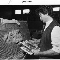 Sculptor Michael Casey looks over photographs of cast iron ornaments to help him in the restoration of the California State Capitol building