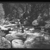 Children and adults playing and swimming in a river