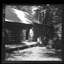 A cabin with two men in front