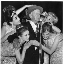 Jimmy Durante, hams it up with a bevy of chorus girls at the California State Fair