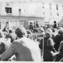 Tom Hayden (Thomas E. Hayden), antiwar and civil rights activist, at microphone. Next to Hayden (with beard) is fellow activist John Irwin